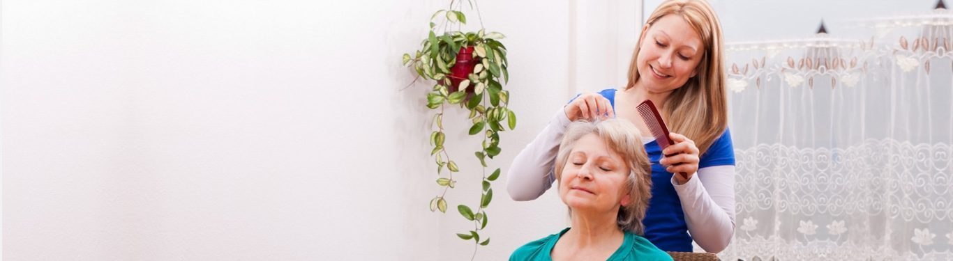 Caregiver combing a senior client's hair