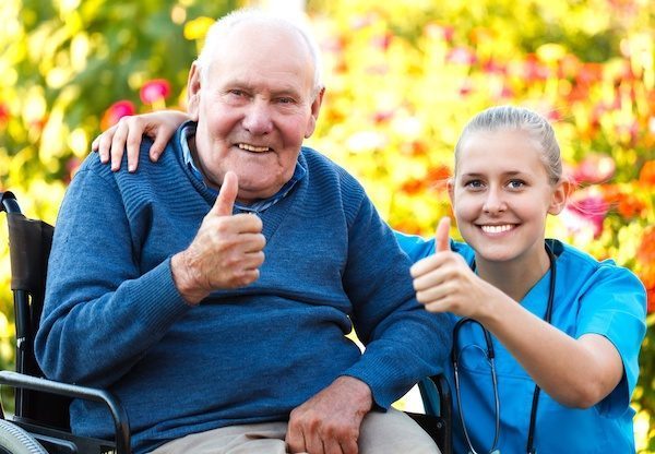 Caregiver with a senior client in a wheelchair, both smiling